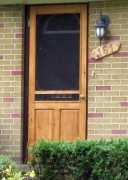 photo of light wood partial view storm on brick house.