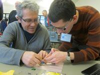 Photo of two men fixing a phone.